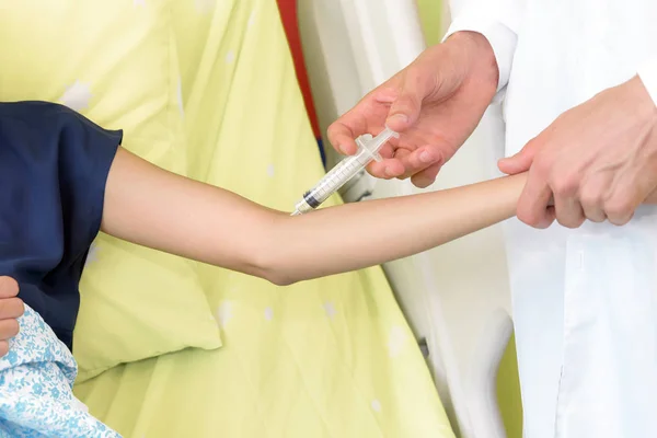Врач вакцинирует пациента шприцем в больнице — стоковое фото