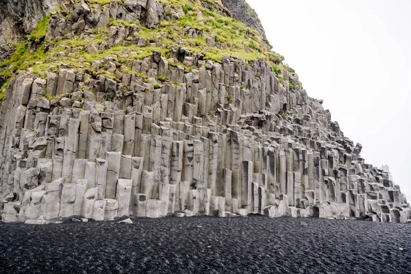 Basalto colonne di pietra e spiaggia di sabbia nera, Reynisfjara, Islanda — Foto Stock