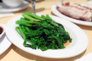 Kızarmış yeşil sebze beyaz plaka üzerine ilave edin.