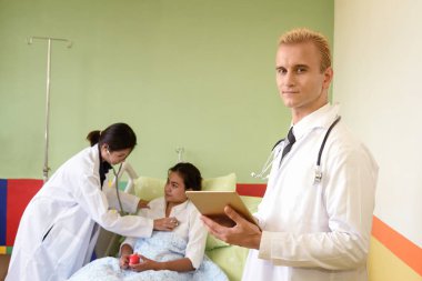 Beyaz ve Asya doktor hastanede dijital tablet tutun