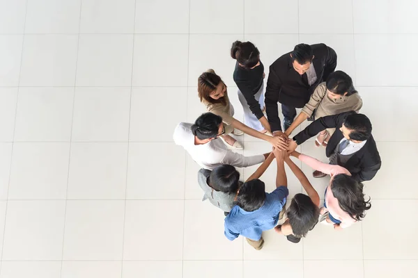 Vista dall'alto del lavoro di squadra di partner multietnici aziendali, squadra unire le mani insieme Immagine Stock