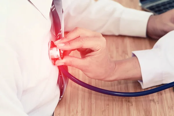 Läkare handen håller stetoskopet framför patientens bröst, lyssna på hjärtslag — Stockfoto