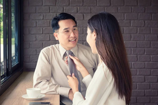 Woman help knot necktie of man, get ready to work in the morning