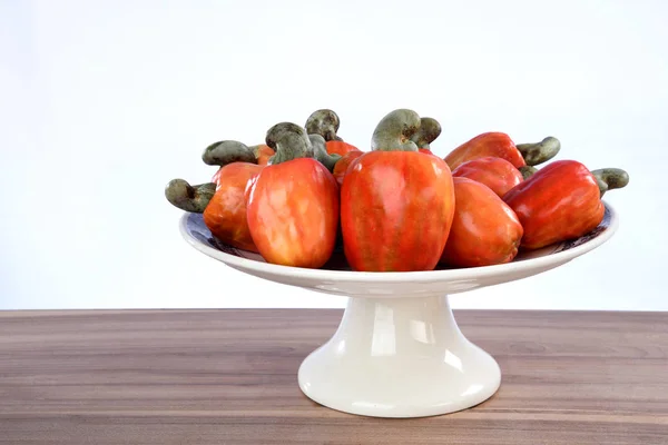 Cashew nuts isolated with glass of fruit juice on white backgrou — Stock Photo, Image