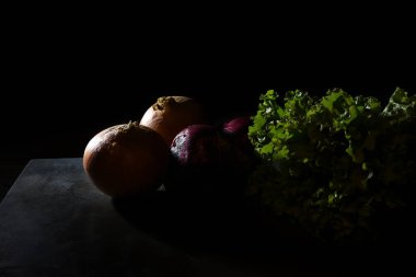 Kenar lambalı bir taşın üzerinde soğan ve marul