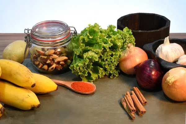 Table en pierre avec pomme de terre oignon ail banane et épices . — Photo