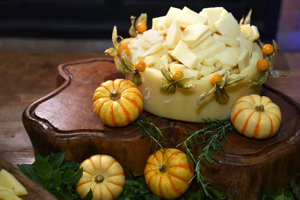 Cheese with small pumpkins on wooden table with herbs and pepper — Stock Photo, Image