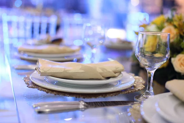 De instelling van de tabel met glazen, borden, servetten en voedsel — Stockfoto