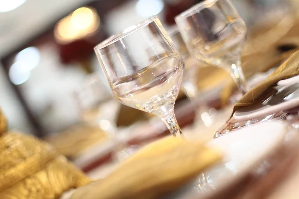 De instelling van de tabel met glazen, borden, servetten en voedsel — Stockfoto