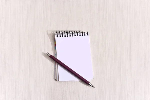 Notepad with a pen on the table in aerial view with space for te — Stock Photo, Image