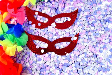 red carnival costume mask in colorful confetti and streamers on  clipart