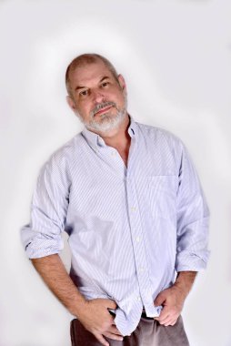 Beyaz tişörtlü beyaz sakallı beyefendi beyaz arka planda duruyor.