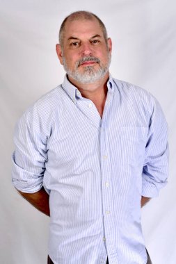 Beyaz tişörtlü beyaz sakallı beyefendi beyaz arka planda duruyor.