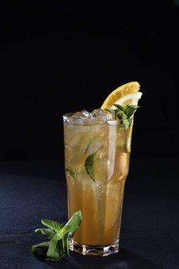 Siyah arka planda cam bardakta buzlu narenciye kokteyli.,