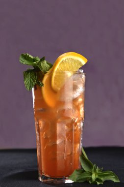 Renkli arka planda cam bardakta buzlu narenciye kokteyli ile nefis bir içecek.,