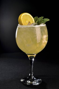 Siyah arka planda cam bardakta buzlu narenciye kokteyli.,