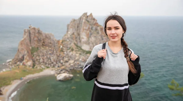 Туристическая девушка на берегу озера Байкал на фоне скалы Шаманка, остров Ольхон . — стоковое фото