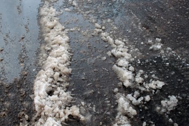 Çamurlu, yolda kar ve toprak karışımı. Yol kardan temizlenmedi. İlkbahar buzu. Kar eriyor. Su birikintisi ve kar