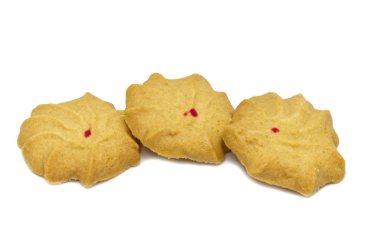 Sütlü bisküvi, tereyağı ve bal aromalı. Bir yığın lezzetli tatlı yemek ve faydalı kurabiye. Beyaz arka planda izole edilmiş. Üst krakerdeki kırmızı nokta. 