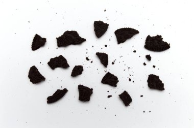 Beyaz arka planda kırıntıları olan Oreo Bisküvileri. Vanilya aromalı çikolatalı sandviç kurabiyesi..