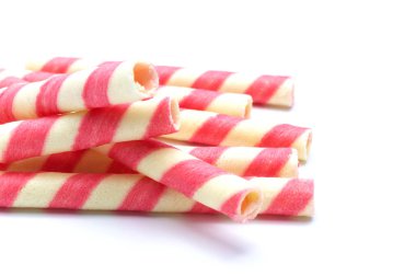 Beyaz arkaplanda izole edilmiş pembe çizgili gofret ruloları.
