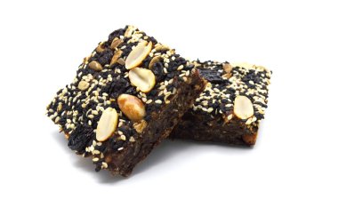 Ev yapımı ekmek ve fırın brownisi, üstüne yer fıstığı, üzümler, güneş tohumları beyaz ve siyah susam tohumları, beyaz arka planda.. 