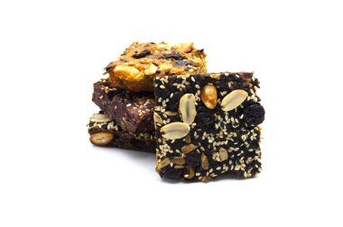 Ev yapımı ekmek ve fırın brovnisi, üstüne yer fıstığı, üzümler, güneş çekirdekleri beyaz ve siyah susam tohumları, beyaz arka planda.. 