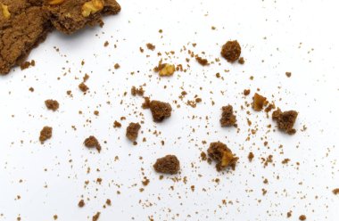 Çikolata parçacıklı tereyağlı kurabiyeler. Beyaz arka planda dağınık kırıntılar var..