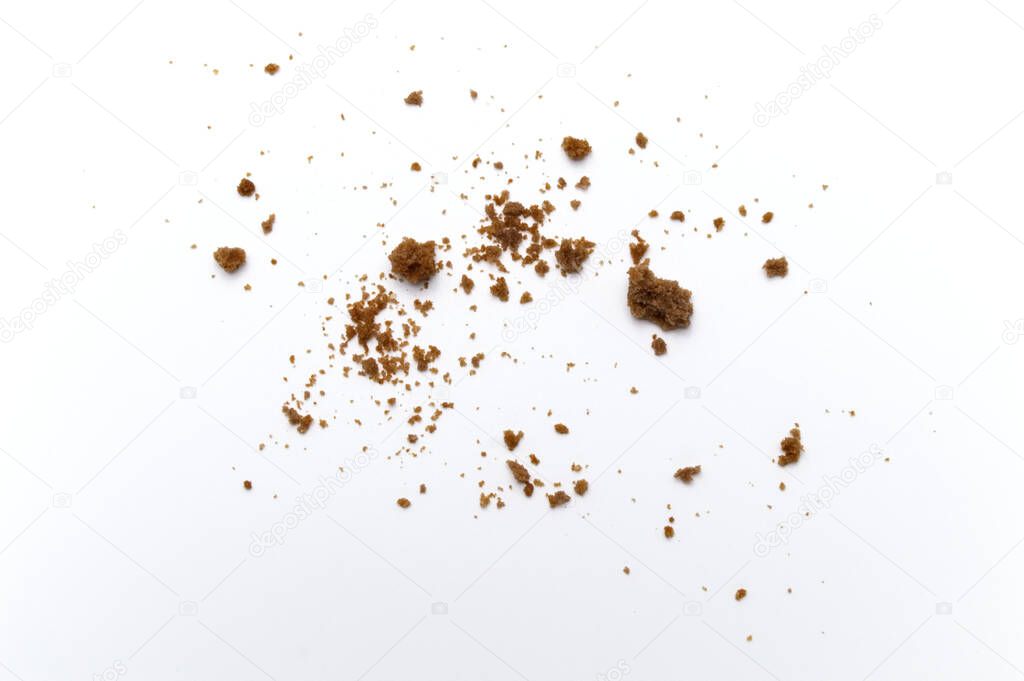 Scattered crumbs of chocolate chip butter cookies on white background.