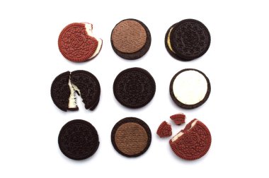 Kremalı ve kremalı Oreo kurabiyeleri ve kremayı beyaz arka planda, tatlı krema, çikolata, fıstık ezmesi ve kırıntılı kırmızı kadife..