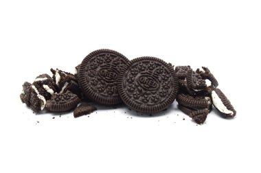 Beyaz arka planda çatlak ve kırıntıları olan Oreo Bisküvileri. İçi krema aromalı sandviç kurabiyeleri Tayland 'da en çok satan tatlıdır..  