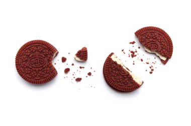 Beyaz arka planda Oreo bisküvileri ve kırıntıları. Peynirli kek aromalı kırmızı kadife sandviç kurabiyesi. Tayland 'da Oreo' nun sınırlı sayıda üretimi.