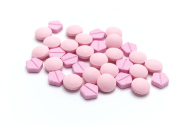 Reçeteli ilaçlar, ilaç hapları ve pembe tonlu tabletler. Beyaz arka planda. Seçici odak.