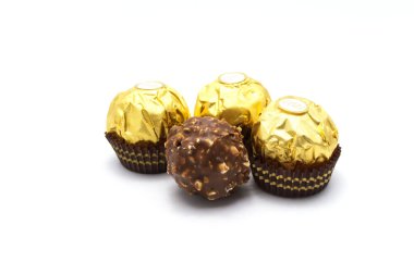 Ferrero Rocher, fındık ve lüks lezzetlerle dolu birinci sınıf çikolata topu tatlısı. Beyaz arka planda izole edilmiş İtalyan çikolata şekerleri.