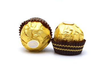 Ferrero Rocher, fındık ve lüks lezzetlerle dolu birinci sınıf çikolata topu tatlısı. Beyaz arka planda izole edilmiş İtalyan çikolata şekerleri.