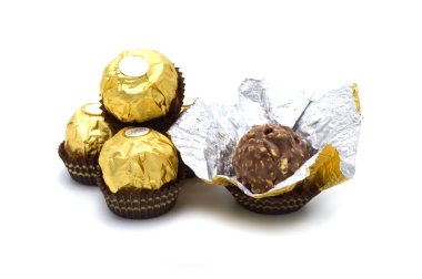 Ferrero Rocher, fındık ve lüks lezzetlerle dolu birinci sınıf çikolata topu tatlısı. Beyaz arka planda izole edilmiş İtalyan çikolata şekerleri.