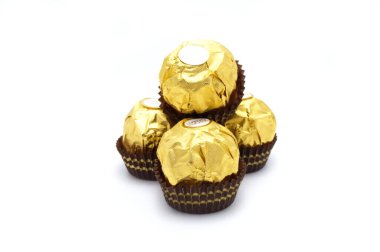 Ferrero Rocher, fındık ve lüks lezzetlerle dolu birinci sınıf çikolata topu tatlısı. Beyaz arka planda izole edilmiş İtalyan çikolata şekerleri.
