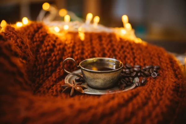 Kahveli ve kahve çekirdekli Cupronickel kahve çifti Noel çelenkleriyle süslenmiş örgü bir eşarp örüyor.