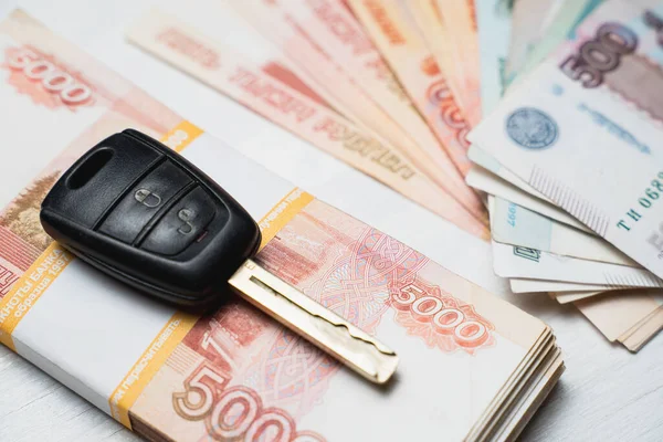 Araba anahtarı ruble banknotlarla dolu bir destenin üzerinde duruyor.