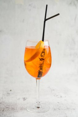 Aperol Spritz kokteyli, açık arkaplanda buz ve turuncu bir bardakta.