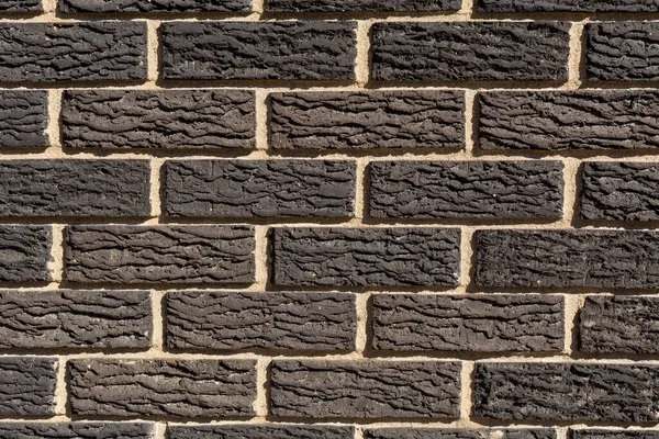 Decorative textured black brick wall.