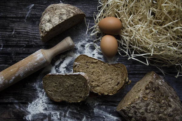 Esmer ekmek dilimleri ve koyu arkaplanda somun.