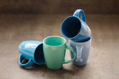 Gri arka planda dört farklı renkte çay fincanı.