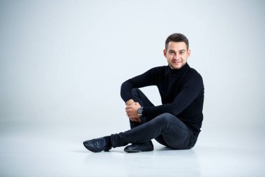 Siyah golf ve kot giyen genç iş adamı.