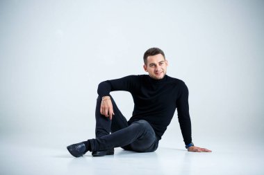 Siyah golf ve kot giyen genç iş adamı.