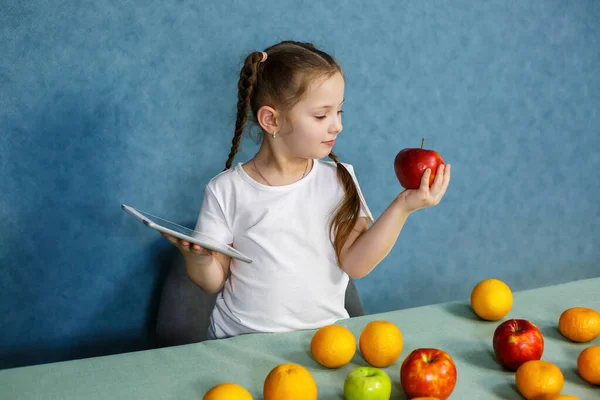 Liten Flicka Vit Shirt Håller Tablett Händerna Och Studerar Frukterna — Stockfoto