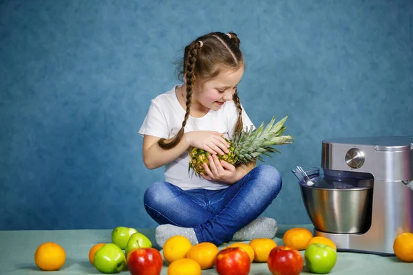 little girl in a white t-shirt loves fruits. She holds a pineapple in her hands
