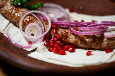 Kebap ızgarasında pişmiş bir yemek. Gürcü yemekleri. Soğan ve nar tohumlarıyla süslenmiş.