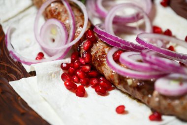 Kebap ızgarasında pişmiş bir yemek. Gürcü yemekleri. Soğan ve nar tohumlarıyla süslenmiş.