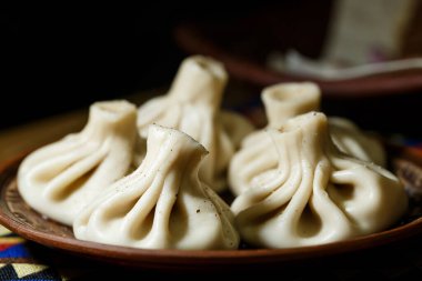 Gürcistan ulusal yemeği Khinkali. Kil tabağa konmuş.